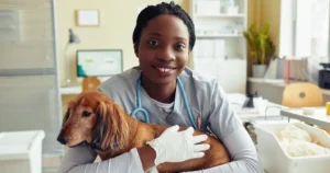 The role of Veterinary Technician Assistants - Woman smiling and holding a sick dog